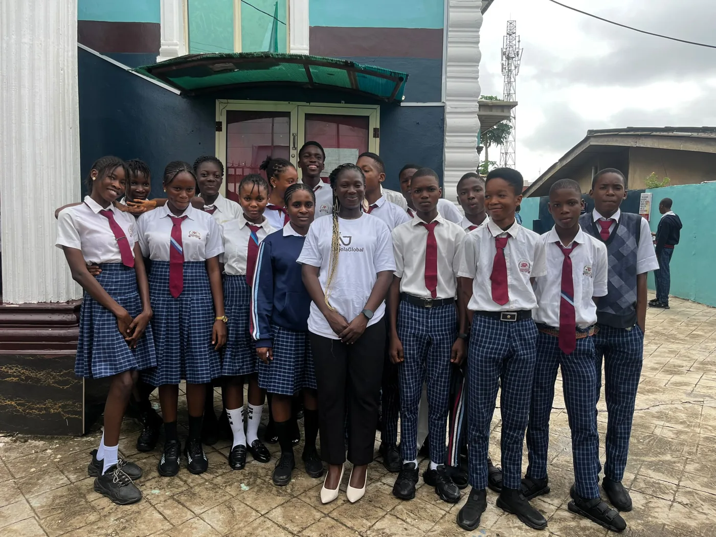 Anjola standing with a group of students in school uniform